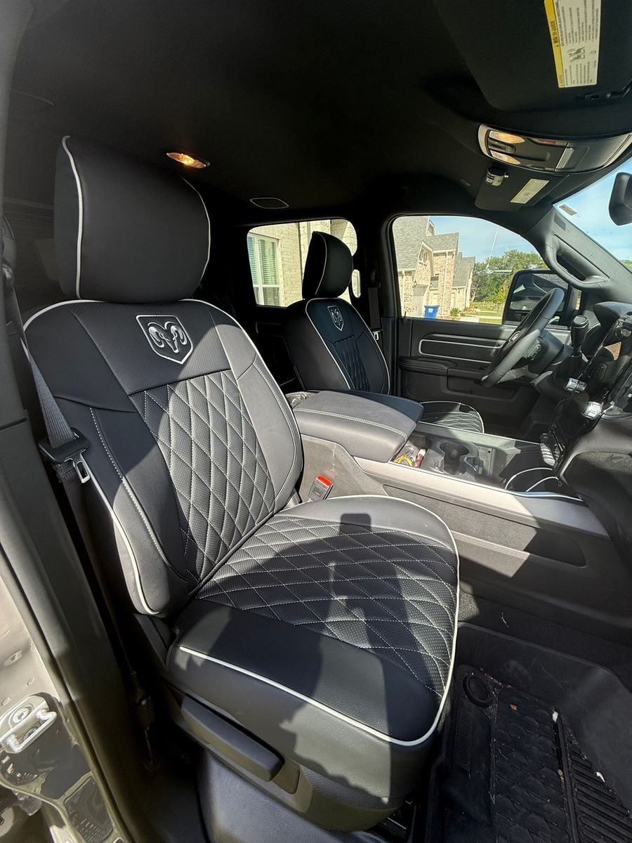 Black diamond seat covers with white piping, close-up