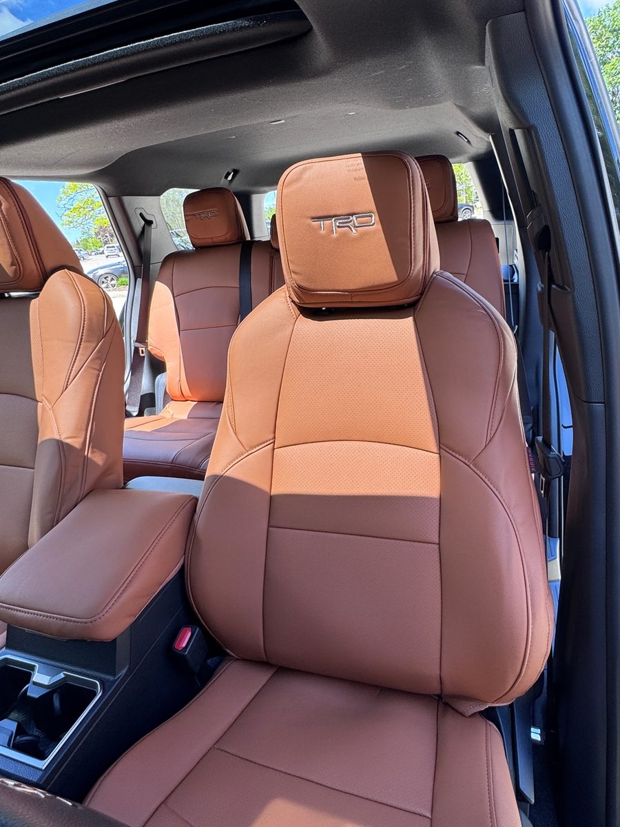 Saddle brown seat covers with an embroidered headrest