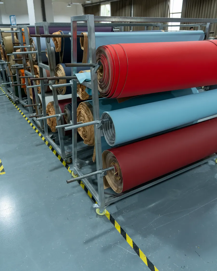 Rolls of seat cover material in red, blue and tan on racks