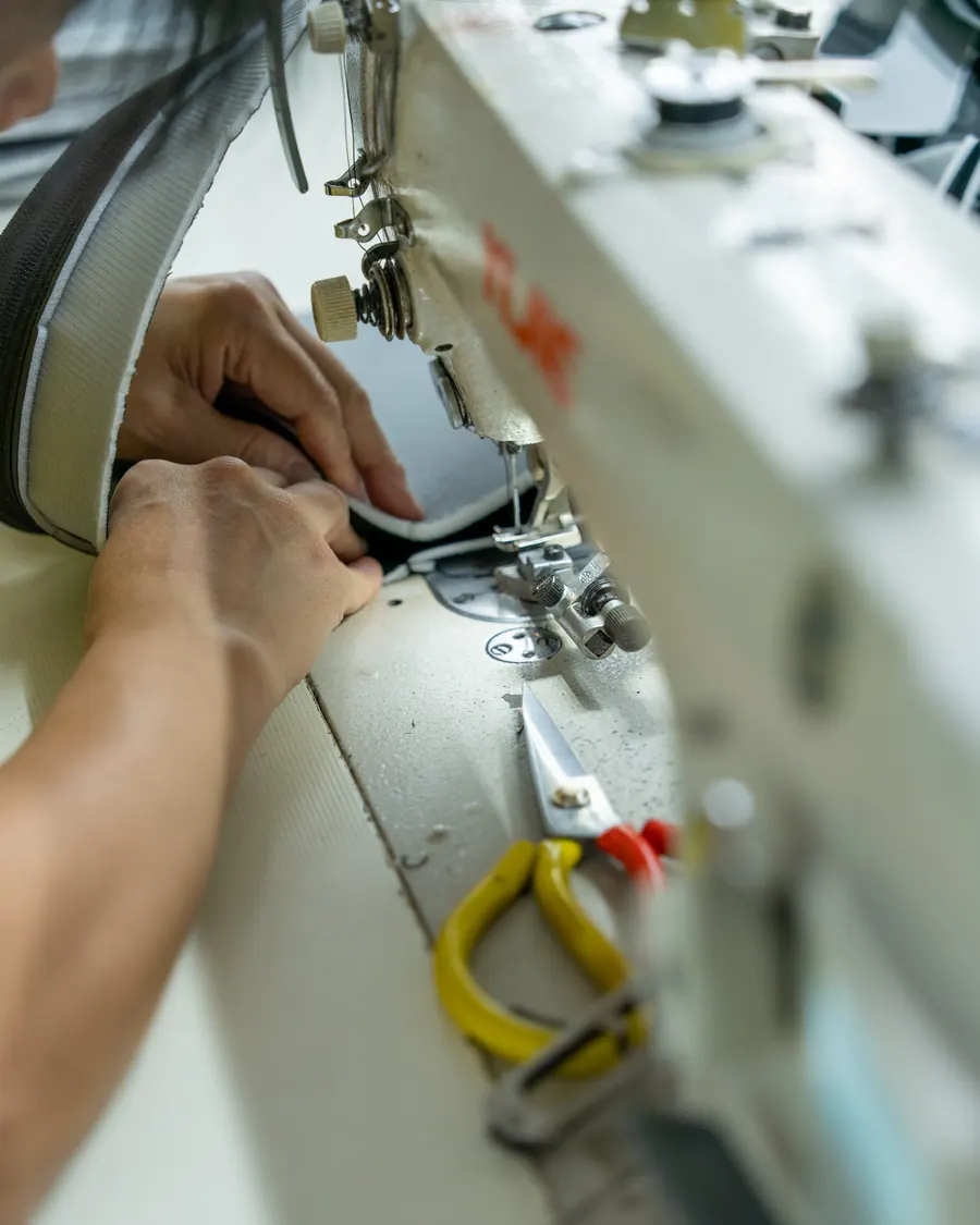 A machinist stitching a seat cover panel